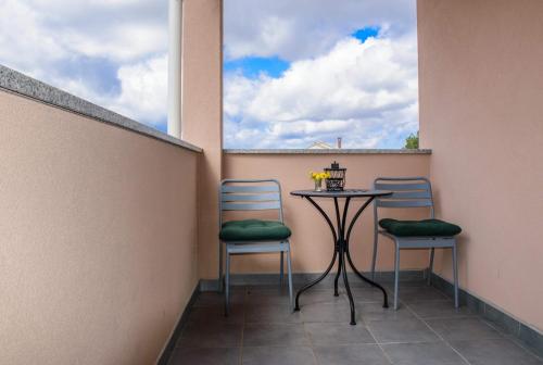 a small balcony with two chairs and a table at Apartman Petar in Ražanac