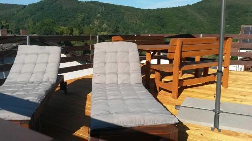 two white chairs on a deck with a table at Ferienhaus Zur Edertalsperre in Edersee