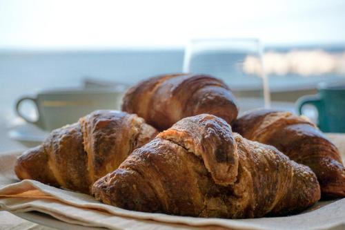 four croissants on a plate on a table at Albergo Ristorante Saverino in Valderice