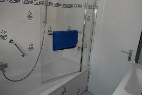 ein Bad mit einer Dusche und einem blauen Handtuch in der Unterkunft Ferienhaus Zur Edertalsperre in Edersee