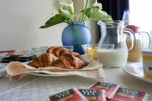 a table with a plate of pastries and a jug of milk at Albergo Ristorante Saverino in Valderice