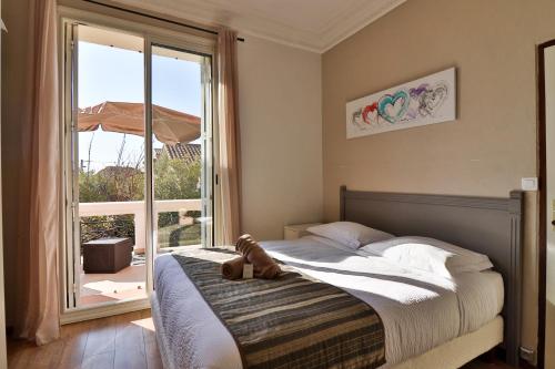 a bedroom with a bed with a teddy bear on it at Hotel La Villa Florida in Bandol