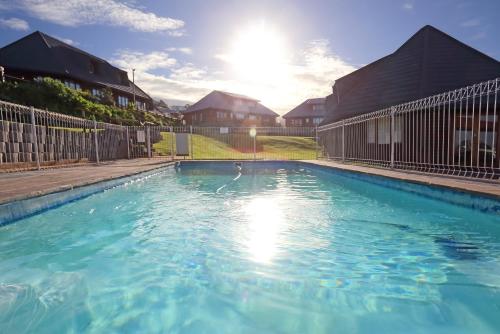 a swimming pool with a swan in the water at Brenton on Sea Cottages in Brenton-on-Sea