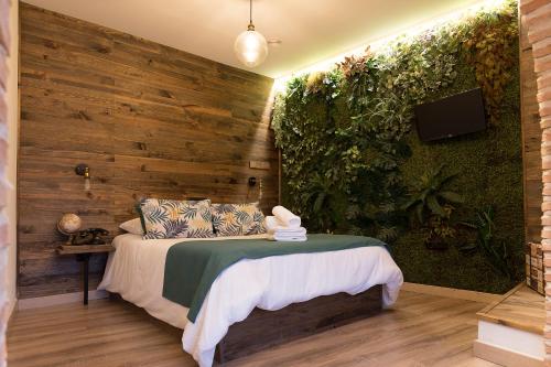 a bedroom with a bed and a wooden wall at Hotel Posada de las Cuevas in Arcos de la Frontera