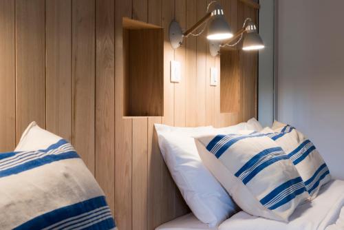 a bedroom with white and blue pillows on a bed at Auberge de la Commanderie in Saint-Émilion