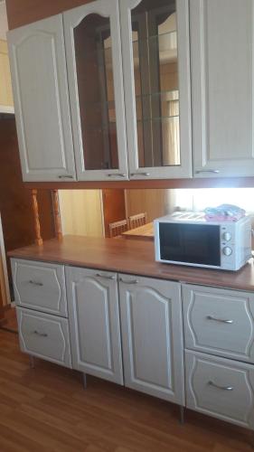 a kitchen with white cabinets and a microwave on a counter at meijeriranta majoitus in Ylistaro