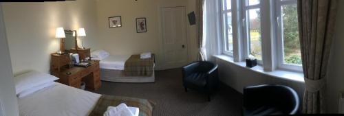 a hotel room with two beds and a window at Loch Shiel Hotel in Acharacle