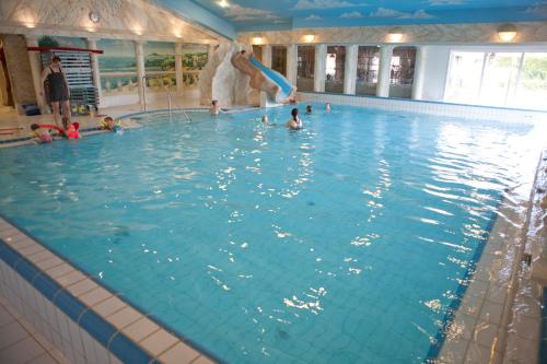a group of people in a large swimming pool at Vakantiepark De Boshoek - Luxe Groepsverblijven op de Veluwe in Voorthuizen