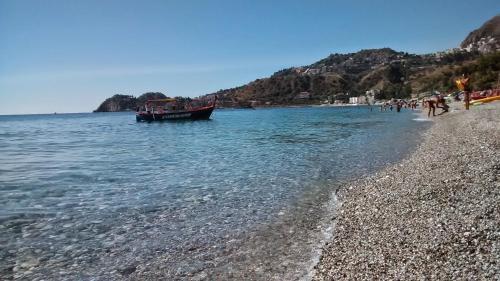 a boat in the water on a beach at Polifemo in Letojanni
