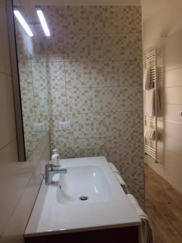 a bathroom with a white sink and a mirror at Residence al Pino in Matera