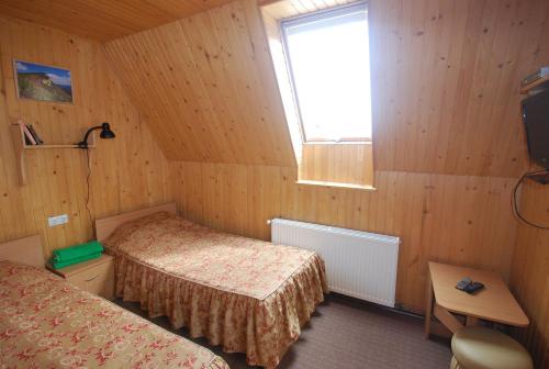 a small room with two beds and a window at Zelena Dacha in Dragobrat