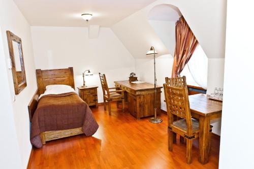 a bedroom with a bed and a desk and a table at Zamek Królewski w Niepołomicach in Niepołomice