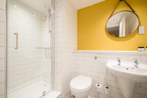 a bathroom with a toilet and a sink and a mirror at The Snowy Owl by Innkeeper's Collection in Cramlington