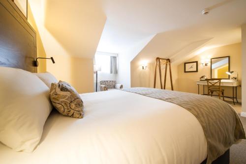 a bedroom with a large white bed in a room at The Snowy Owl by Innkeeper's Collection in Cramlington
