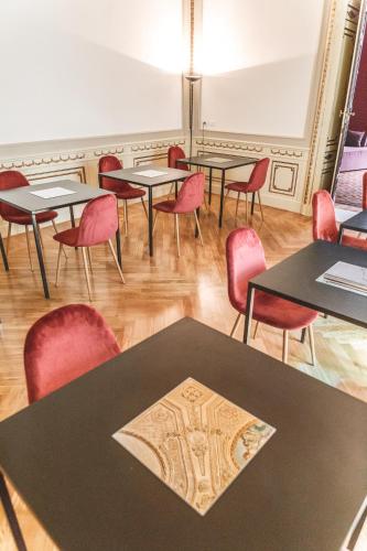 a room with tables and chairs in a room with wood floors at Relais Della Porta in Naples