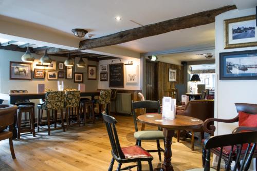 a restaurant with tables and chairs and a bar at The Snowy Owl by Innkeeper's Collection in Cramlington