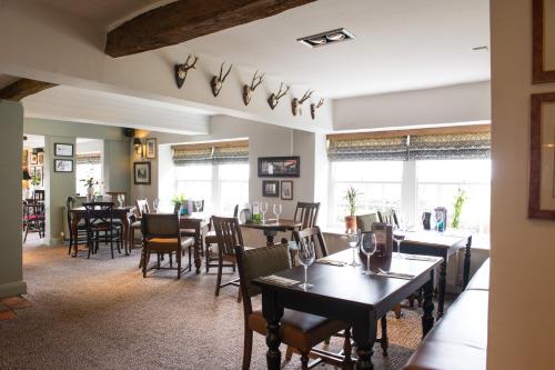 a dining room with tables and chairs and windows at The Snowy Owl by Innkeeper's Collection in Cramlington