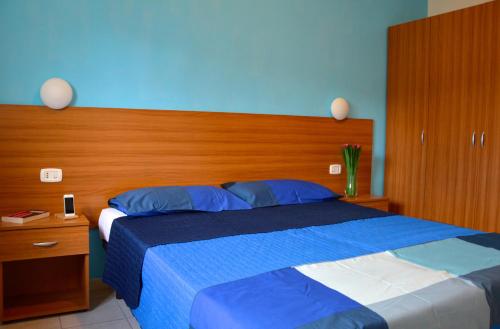 a bedroom with a large bed with a wooden headboard at Tindari Village Camping in Furnari