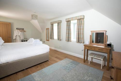 a bedroom with a bed and a dresser and a mirror at Blairmore Farm in Crieff