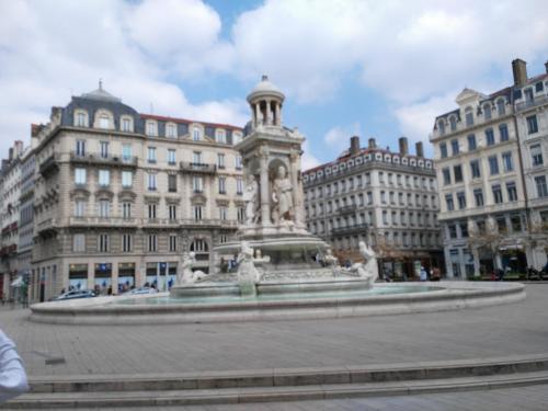 a fountain in a square in front of a building at Mercière Jacobins in Lyon