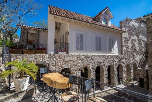 a stone house with a table in front of it at Hotel de Piedra in Bernal