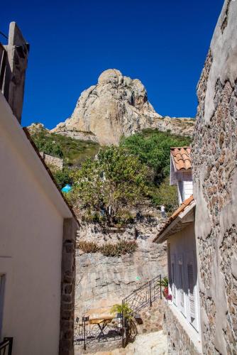 a view of a mountain from between two buildings at Hotel de Piedra in Bernal