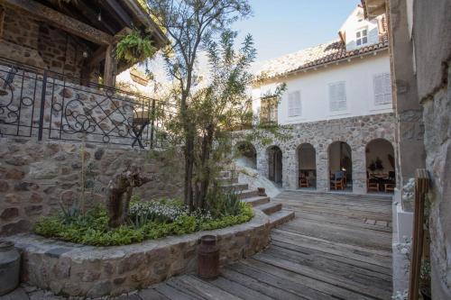 a courtyard of a house with a tree and stairs at Hotel de Piedra in Bernal