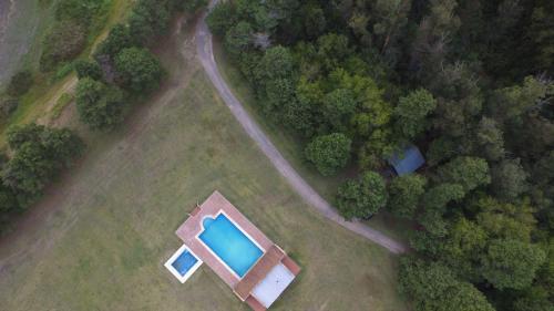 an overhead view of a swimming pool in a field with trees at Estancia Laguna Vitel in Chascomús