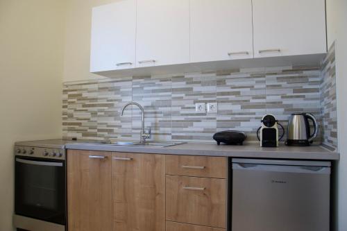 a kitchen with a sink and a counter top at Angelbay Bungalows in Agia Triada