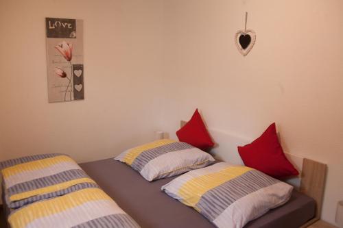 ヴァンガーオーゲにあるStrandperle Wangeroogeのベッドルーム1室(ベッド2台、赤と黄色の枕付)