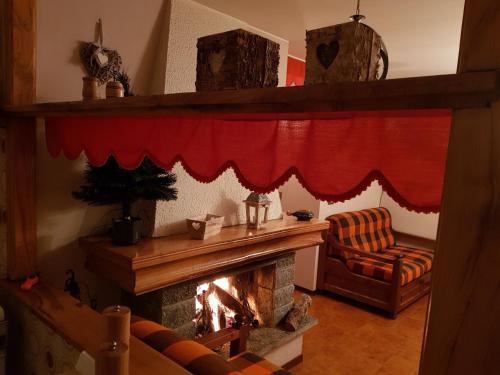 sala de estar con chimenea y cortina roja en Alpirosa, en Challand Saint Anselme