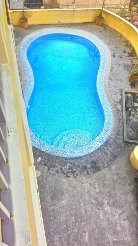 a swimming pool with blue water in a yard at Mmr in Manila