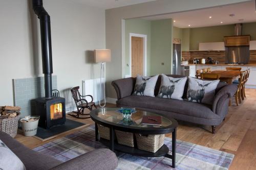 a living room with a couch and a wood stove at Blairmore Farm in Crieff