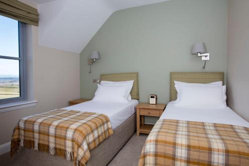 a bedroom with two beds and a window at Blairmore Farm in Crieff