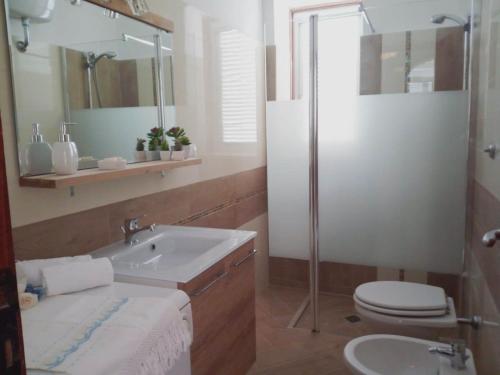 La salle de bains est pourvue d'un lavabo, de toilettes et d'une douche. dans l'établissement Villa Fontanelle, à Villanova di Ostuni