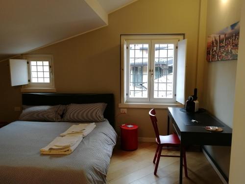 a bedroom with a bed and a desk and a window at Antico Ducato in Bergamo