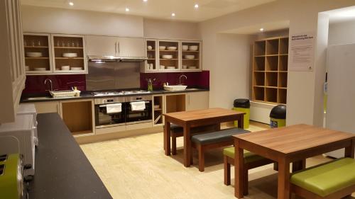 a kitchen with a table, chairs and a refrigerator at YHA London Earl's Court in London