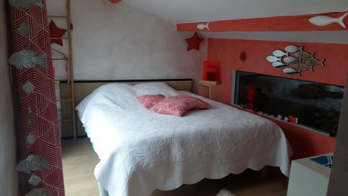 Schlafzimmer mit einem Bett mit weißer Bettwäsche und einem TV in der Unterkunft LA CABANE D'ISA in Sète