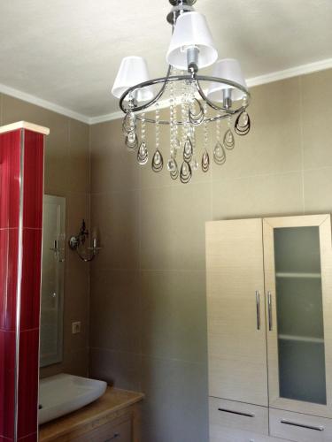 a bathroom with a chandelier hanging from the ceiling at Amfithea House in Siviri