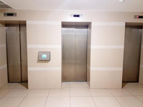 a hallway with three elevators in a building at Most City Apart-Hotel in Dnipro