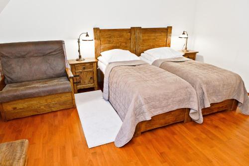 a bedroom with two beds and a chair at Zamek Królewski w Niepołomicach in Niepołomice