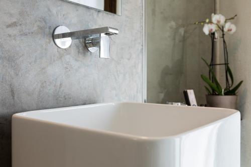 a white sink in a bathroom with a faucet at Relais Bondaz in Aosta