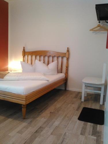 a bed with white sheets and pillows in a room at Landhotel Possendorf in Weimar