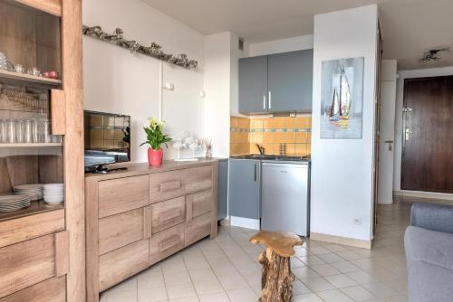 une cuisine avec des armoires bleues et un comptoir dans l'établissement Appartement Le Flamant Rose, à Port-la-Nouvelle