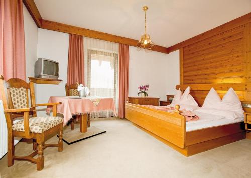 1 dormitorio con cama, mesa y TV en Bruckerhof, en Puchberg am Schneeberg