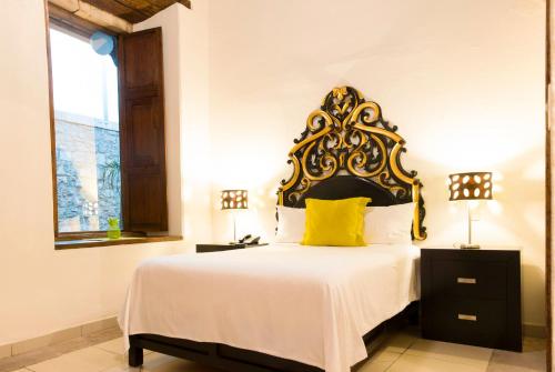 Hotel Expres By Hosting House في موريليا: غرفة نوم بسرير كبير ومخدة صفراء