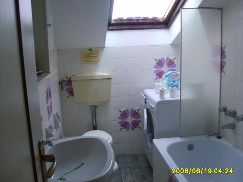 bagno con servizi igienici bianchi e lavandino di Appartamento Cinzia a Misano Adriatico