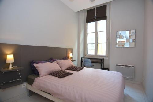 une chambre avec un grand lit avec des oreillers roses dans l'établissement Je suis à Nice, à Nice