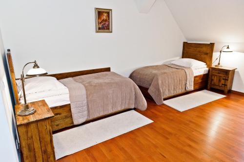 two beds in a room with wooden floors at Zamek Królewski w Niepołomicach in Niepołomice