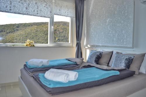 a bed with towels on it in front of a window at Studio apartment More in Rabac